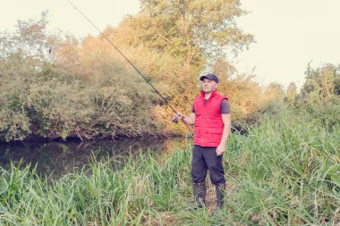 Nehirde spor balıkçılığı. Balıkçı topu fırlatıyor..