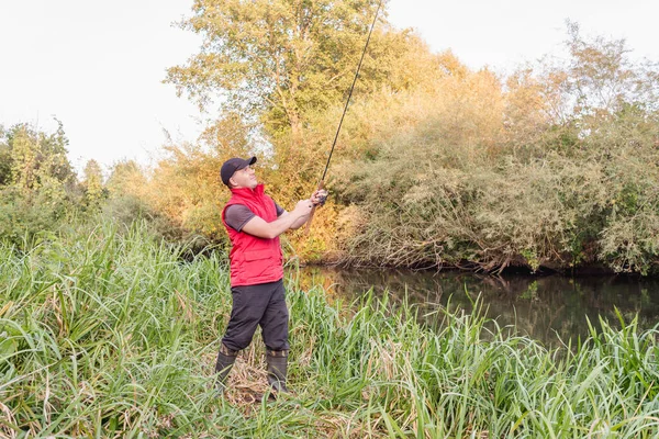Nehirde spor balıkçılığı. Balıkçı topu fırlatıyor..