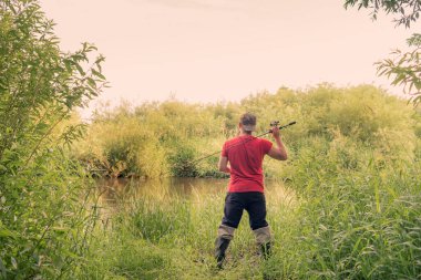 Balıkçı arkadan dönen bir bakış atıyor. Yaz balıkçılık.