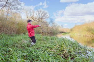 Balıkçı nehre bir olta atar. Arkadan bak.. 