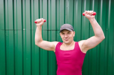 Genç adam halterlerle egzersiz yapıyor. Boks ve spor.