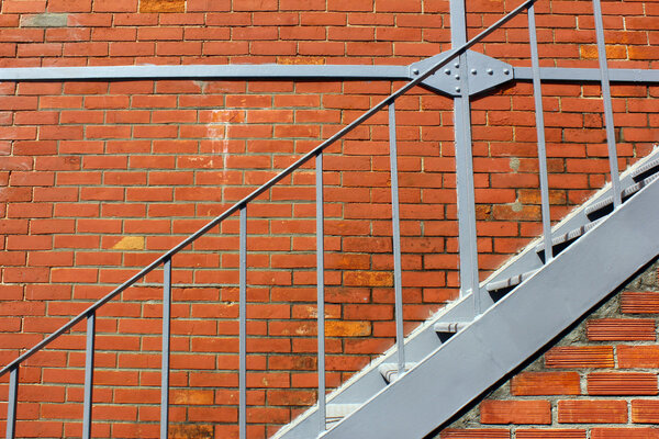 Detail of some iron stairs and a brick wall