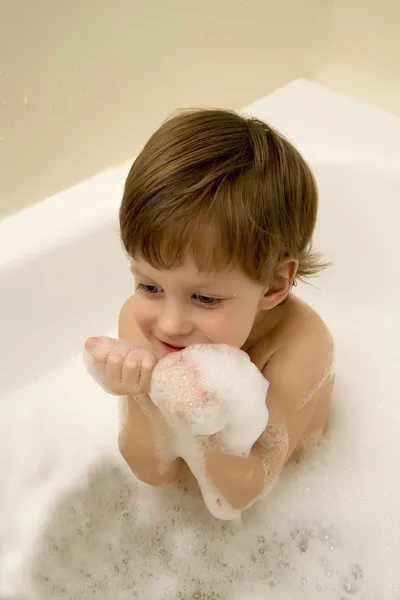 Lindo chico tomando un baño con espuma — Foto de Stock