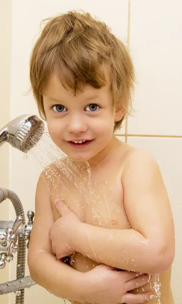 Bañar y sonreír al bebé bajo la ducha — Foto de Stock
