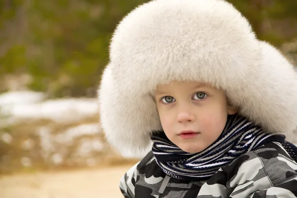 Lindo chico en una gorra con orejeras — Foto de Stock