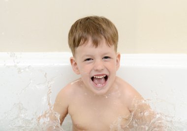 The boy splashes in a bathroom clipart