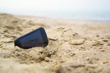 Mobil dokunmatik telefon bir plaj kum