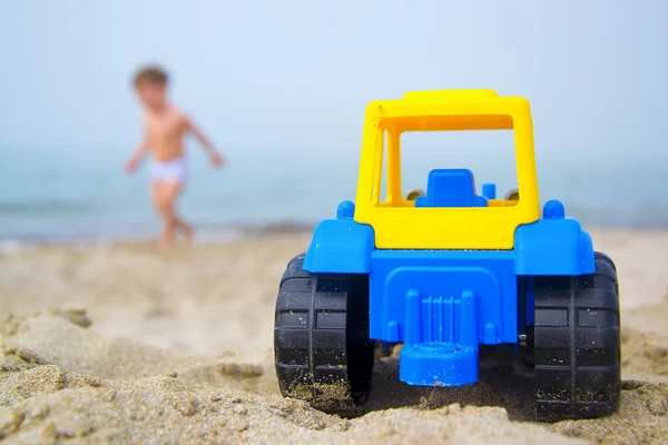 Игрушечный трактор на берегу моря — стоковое фото
