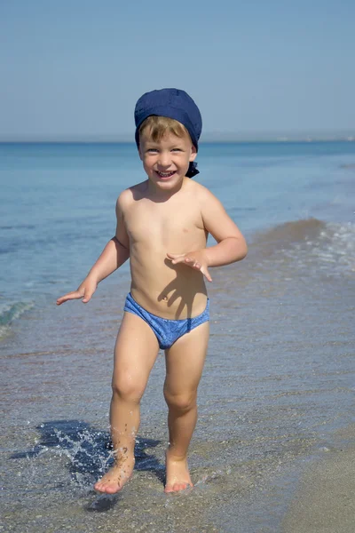 Милый мальчик бежит в море — стоковое фото