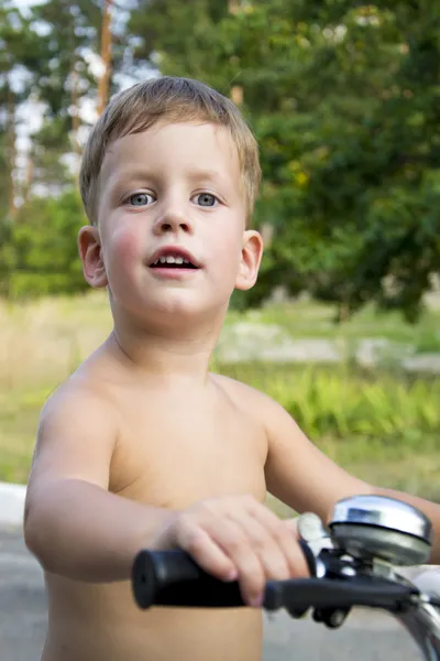 Close-up van portret van schattige drie jaar oude jongen in een fiets — Stockfoto