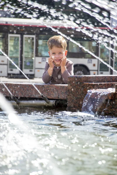 Boy near fountaine in summer day — Stock Photo, Image