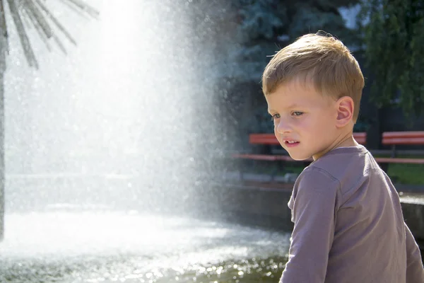 Boy near fountaine in summer day — Stock Photo, Image