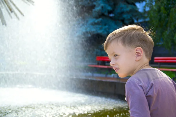 Boy near fountaine in summer day — Stock Photo, Image