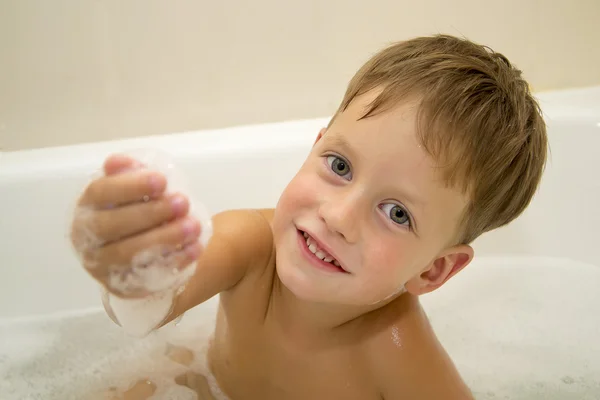 Lindo chico tomando un baño con espuma — Foto de Stock