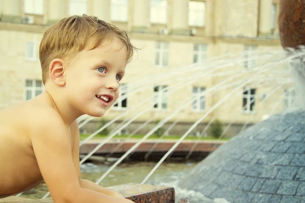 Boy near fountain in summer day — Stock Photo, Image