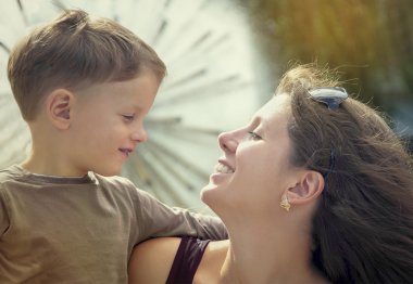 Anne ve küçük oğlu açık havada yakınındaki çeşme şehirdeki