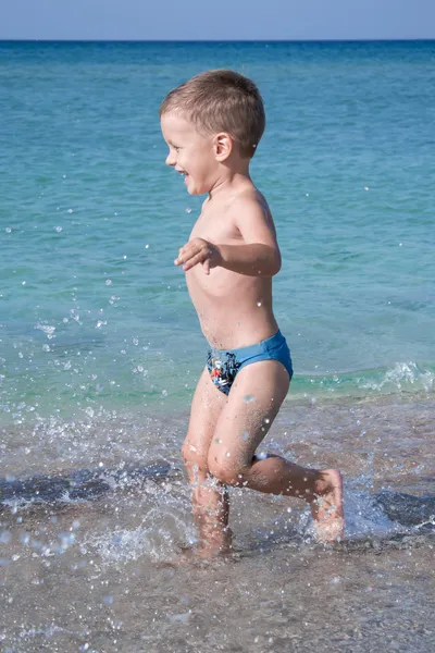 Cute three years child boy is running in sea — Stock Photo, Image