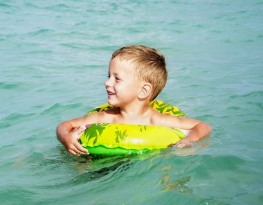 Kauçuk halka ile Denizde yüzme keyfi mutlu çocuk