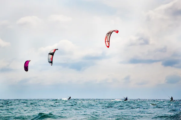 Tre kitesurfare njuter surf. — Stockfoto