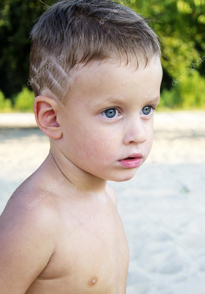 Three years boy with cool hairdress on beach