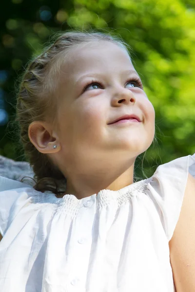 Portrait of a beautiful little girl in the forest. looking up — Stock Photo, Image