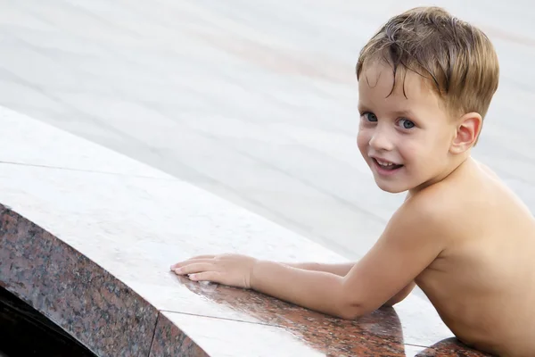 Boy near fountain in summer day — Stock Photo, Image