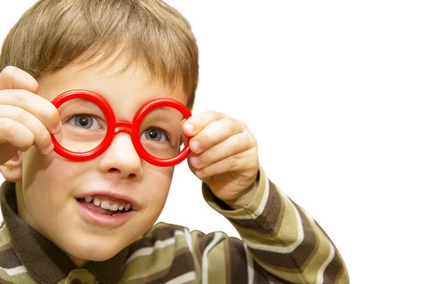 Niedlicher kleiner Junge schaut durch eine rote Spielzeugbrille — Stockfoto