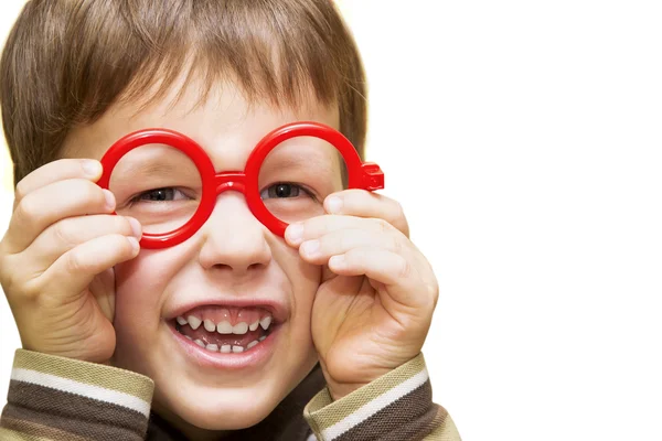 Niedlicher kleiner Junge schaut durch eine rote Spielzeugbrille — Stockfoto