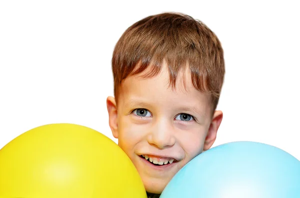 Niedlicher Junge mit blauen und gelben Luftballons auf weißem Grund — Stockfoto