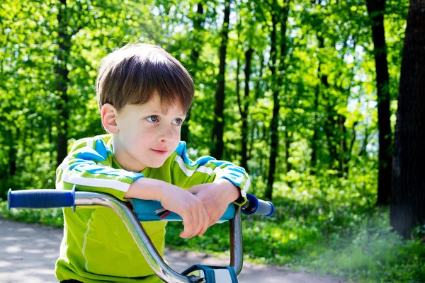 Vier jaar jongen en fiets in stadspark — Stockfoto