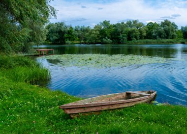 boat moored near the river bank, wooden fishing boat in the village.