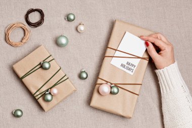 Kraft kağıdına sarılı hediye kutularıyla Noel arkaplanı. Xmas kutlaması, kış tatili hazırlıkları. Şenlikli maketler, üst görünüm, düz yatış doğal kolonlar.