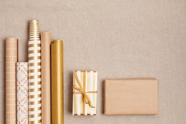 Hediye kutuları ve rulo ambalaj kağıtlarıyla Noel arkaplanı. Xmas kutlaması, kış tatili hazırlıkları. Şenlikli maket, üst görünüm, düz yatış