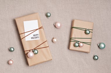 Kraft kağıdına sarılı hediye kutularıyla Noel arkaplanı. Xmas kutlaması, kış tatili hazırlıkları. Şenlikli maketler, üst görünüm, düz yatış doğal kolonlar.