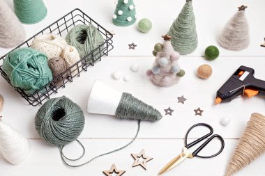 Noel sanatları hobisi el yapımı iplik konisi xmas ağaçlarıyla doğal renklerde. Yılbaşı süsü yapmak için rahatlatıcı, depresif bir hobi. Diy atölyesinin üst görünümü