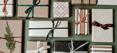 Yeşil zemin üzerinde hediye kutularıyla Noel arkaplanı. Xmas kutlaması, kış tatili hazırlıkları, gizli Noel Baba, takvim konsepti. Bayram afişi, web sitesi başlığı, üst görünüm, düz yatış