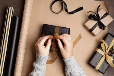 Noel arkaplanı hediye kutuları ve rulo ambalaj kağıtlarıyla dolu. Xmas kutlaması, kış tatili hazırlıkları. Şenlikli maket, üst görünüm, düz yatış