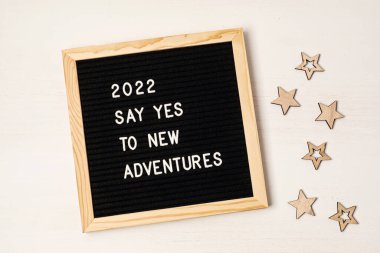 İçinde 2022 nolu metin olan mektup panosu yeni maceralara evet diyor. Motivasyon alıntısı, yeni yıl hedefleri ve çözüm konsepti. Düz yatış, üst görünüm