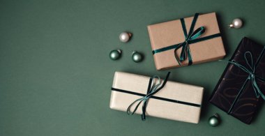 Yeşil zemin üzerinde hediye kutularıyla Noel arkaplanı. Xmas kutlaması, kış tatili hazırlıkları, gizli Noel Baba, takvim konsepti. Bayram afişi, web sitesi başlığı, üst görünüm, düz yatış