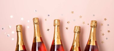 Şampanyalı pankart mı yoksa pembe arka planda konfetili köpüklü şarap mı? Noel, yeni yıl partisi, doğum günü veya düğün kutlaması fikri. Üst manzara, düz uzanma