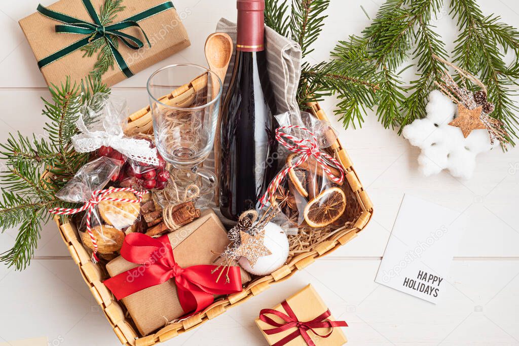 Refined Christmas gift basket for culinary enthusiats with bottle of wine and mulled wine ingredients. Corporate hamper or personal present for cooking lovers, foodies and gourmands.