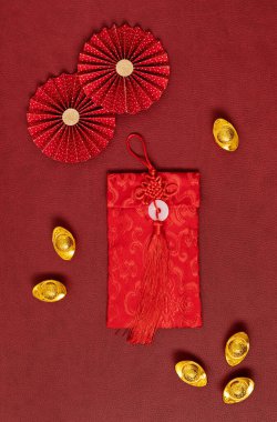 Çin Yeni Yıl Festivali dekorasyonu kırmızı arka planda. Geleneksel ay yeni yılı kırmızı cepleri, kağıt fanları ve altın külçeleri yazı, servet, refah ve zenginlik anlamına gelir. Düz yatış, üst görünüm