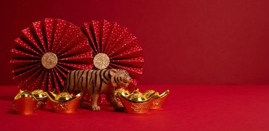 Çin Yeni Yıl Festivali dekorasyonu kırmızı arka planda. Geleneksel yeni yıl külçeleri, kağıt hayranları. Uzayı kopyala, afiş