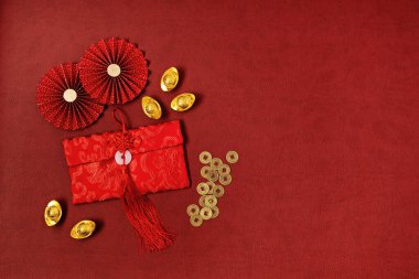 Çin Yeni Yıl Festivali dekorasyonu kırmızı arka planda. Geleneksel ay yeni yılı kırmızı cepleri, altın külçeleri servet, refah ve zenginlik anlamına gelir. Düz yatış, üst görünüm