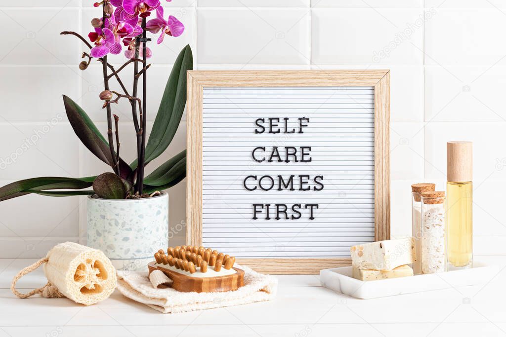 Bathroom styling and organization. Letter board with text Self care comes first. Organic lifestyle and skin care products. 