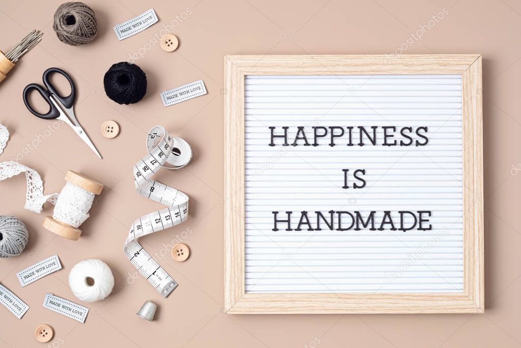 Sewing supplies and accessories for needlework and letter board with text Happiness is handmade