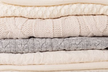 Soğuk hava için sıcak beyaz örgü giysiler yığını. Konforlu organik kazaklar. Hygge tarzı fikir