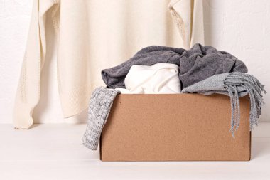Soğuk hava için sıcak örgü giysiler yığını bağışlanmaya hazır. Konforlu organik ikinci el kazaklar. Ucuz mağaza konsepti. Hygge tarzı fikir