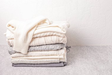 Soğuk hava için sıcak beyaz örgü giysiler yığını. Konforlu organik kazaklar. Hygge tarzı fikir