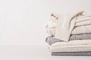 Soğuk hava için sıcak beyaz örgü giysiler yığını. Konforlu organik kazaklar. Hygge tarzı fikir